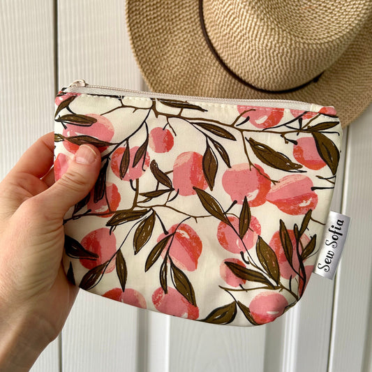 Handmade fruit make up pouch featuring peaches on a cream background.