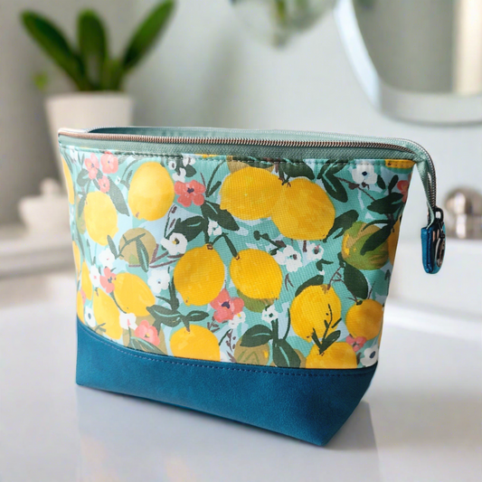 large toiletry bag with zip closure in waterproof soft feel fabric featuring lemons with a faux leather base