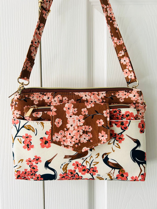 Floral patterned handbag with birds on a white background